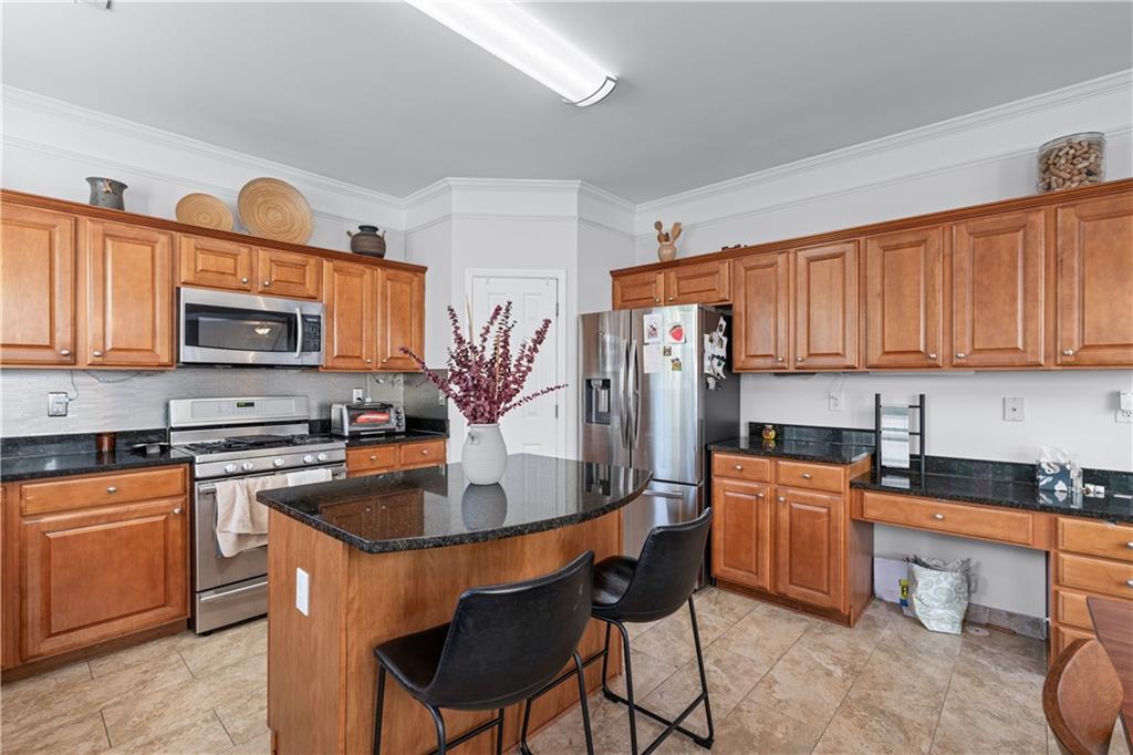 135 Splinter Court Suwanee, GA 30024 - Photo 16 of 47 a kitchen with stainless steel appliances granite countertop a stove top oven a sink dishwasher and cabinets with wooden floor