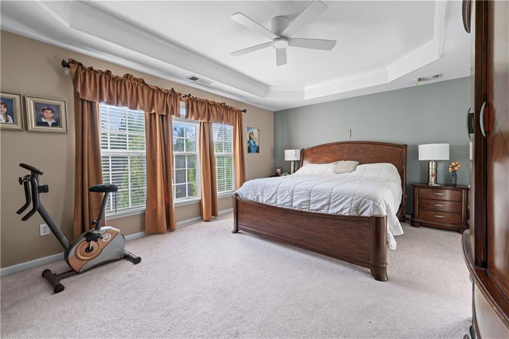 135 Splinter Court Suwanee, GA 30024 - Photo 29 of 47 a bedroom with a bed and a ceiling fan