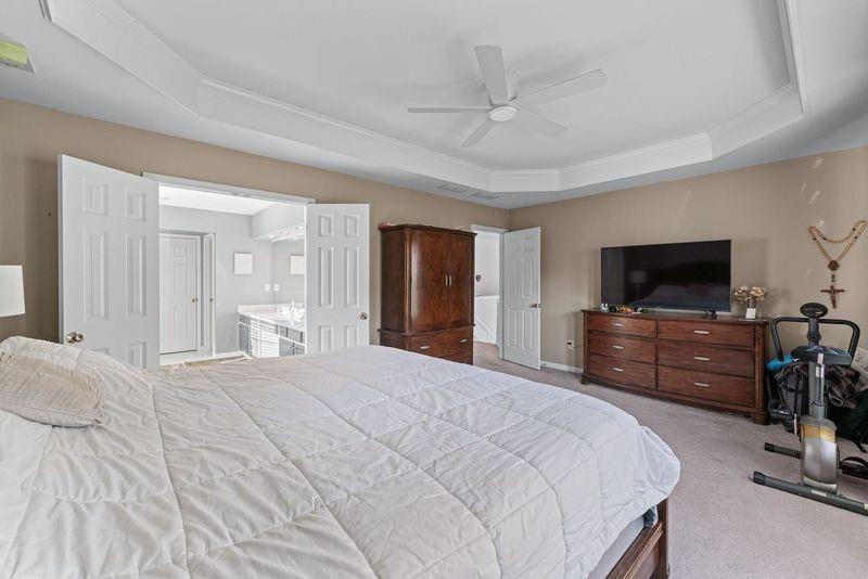 135 Splinter Court Suwanee, GA 30024 - Photo 30 of 47 a bedroom with a bed and a flat screen tv