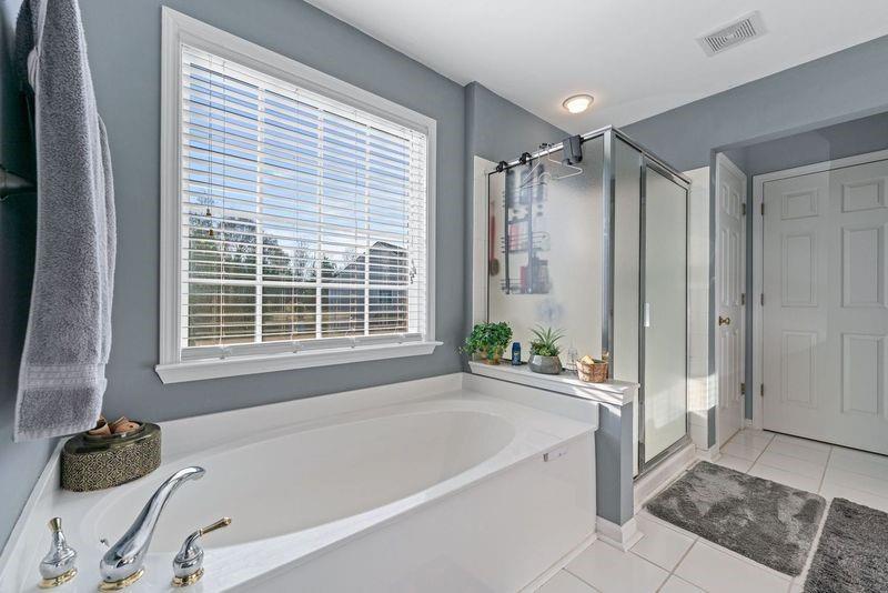 135 Splinter Court Suwanee, GA 30024 - Photo 31 of 47 a bathroom with a tub and a shower