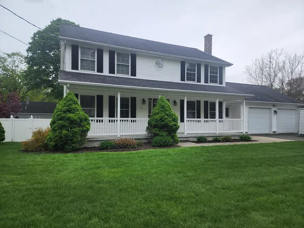 a front view of a house with a yard and trees