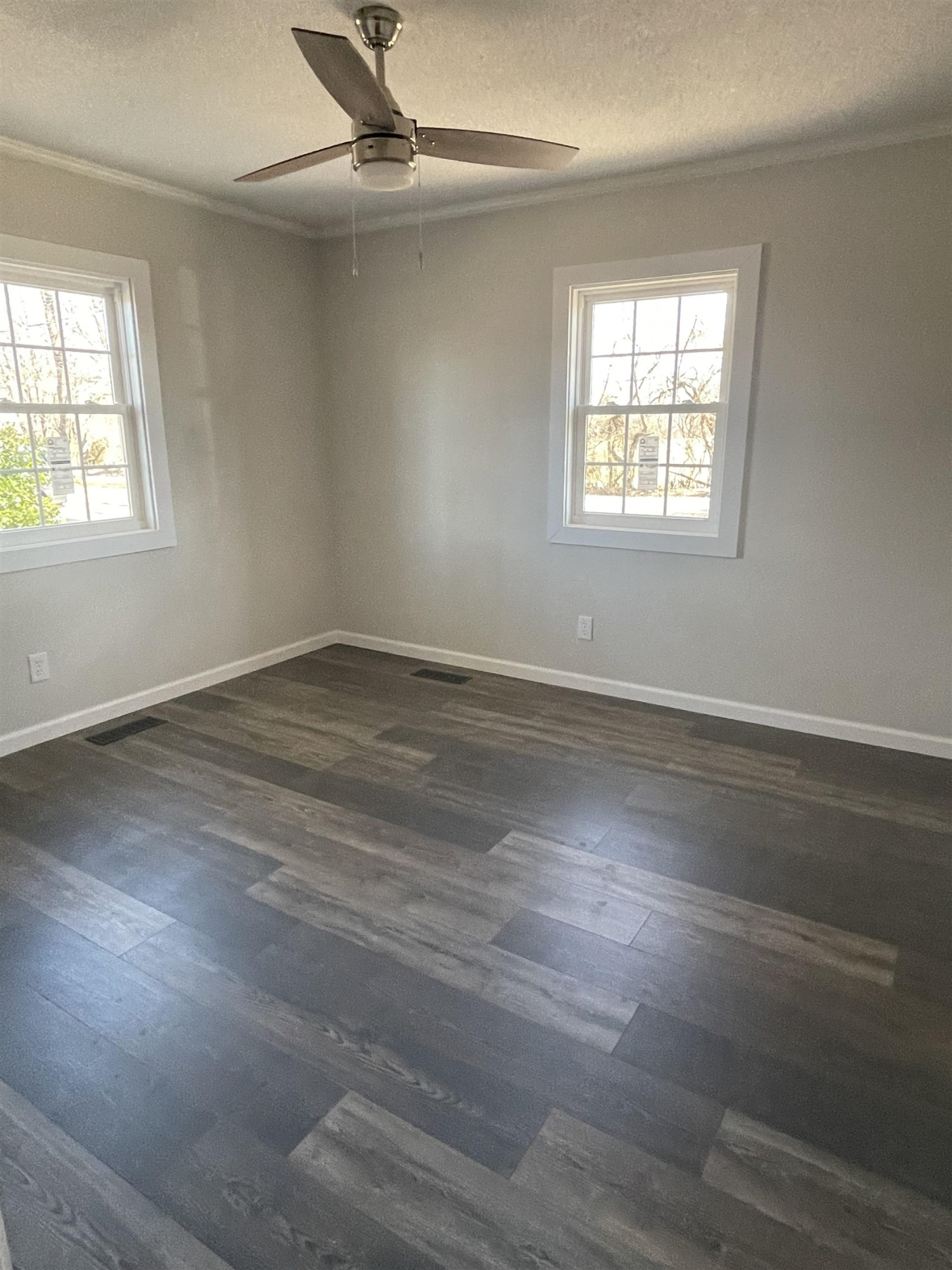 5677 Tatumville Road Newbern, TN 38059 - Photo 11 of 16 an empty room with wooden floor windows and fan