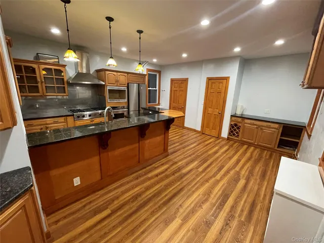 a kitchen with stainless steel appliances granite countertop a sink stove and wooden floor