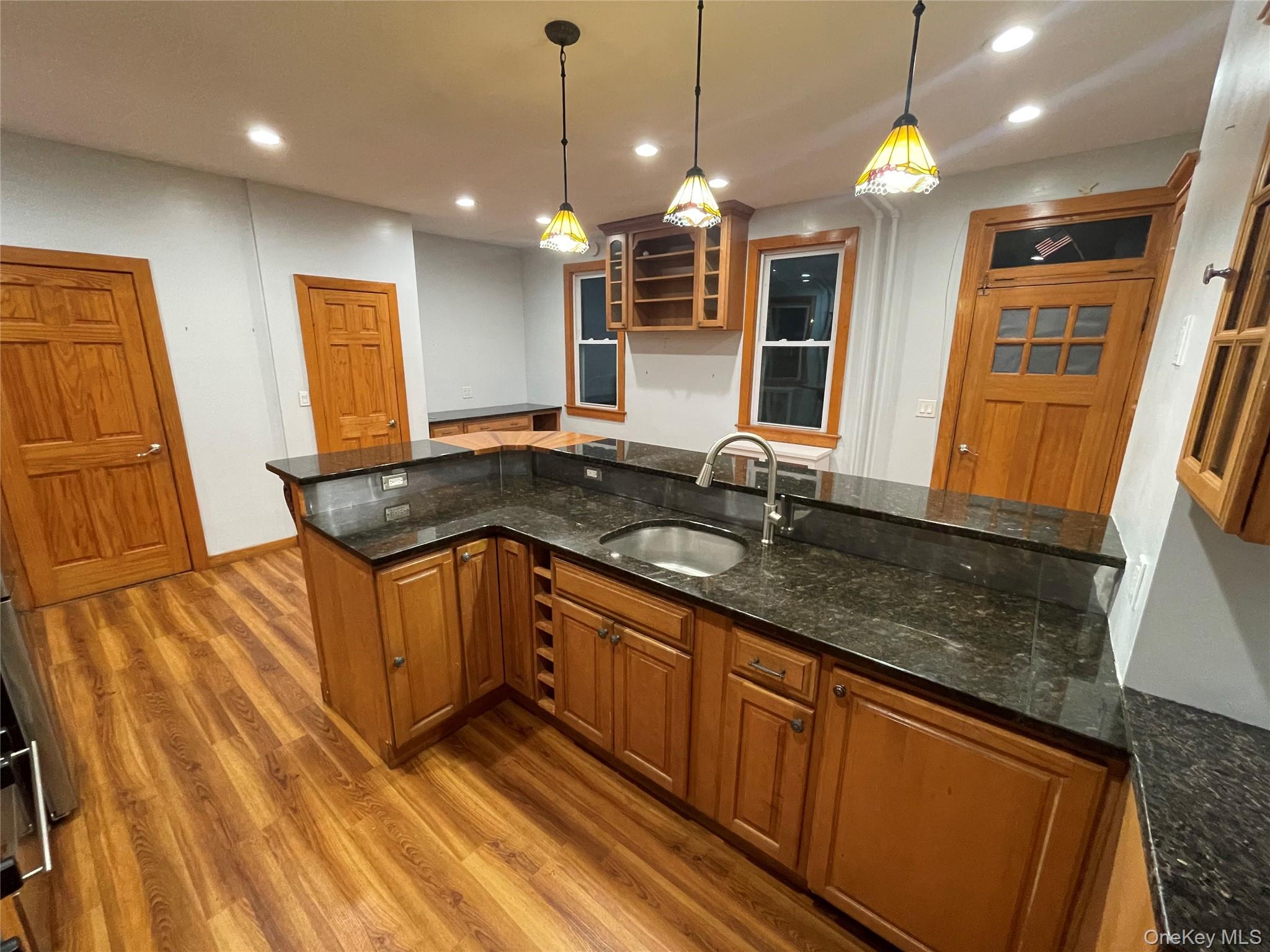 334 Locust Street Mount Vernon, NY 10550 - Photo 5 of 10 Kitchen featuring brown cabinets, dark stone countertops, light wood-style floors, pendant lighting, and recessed lighting