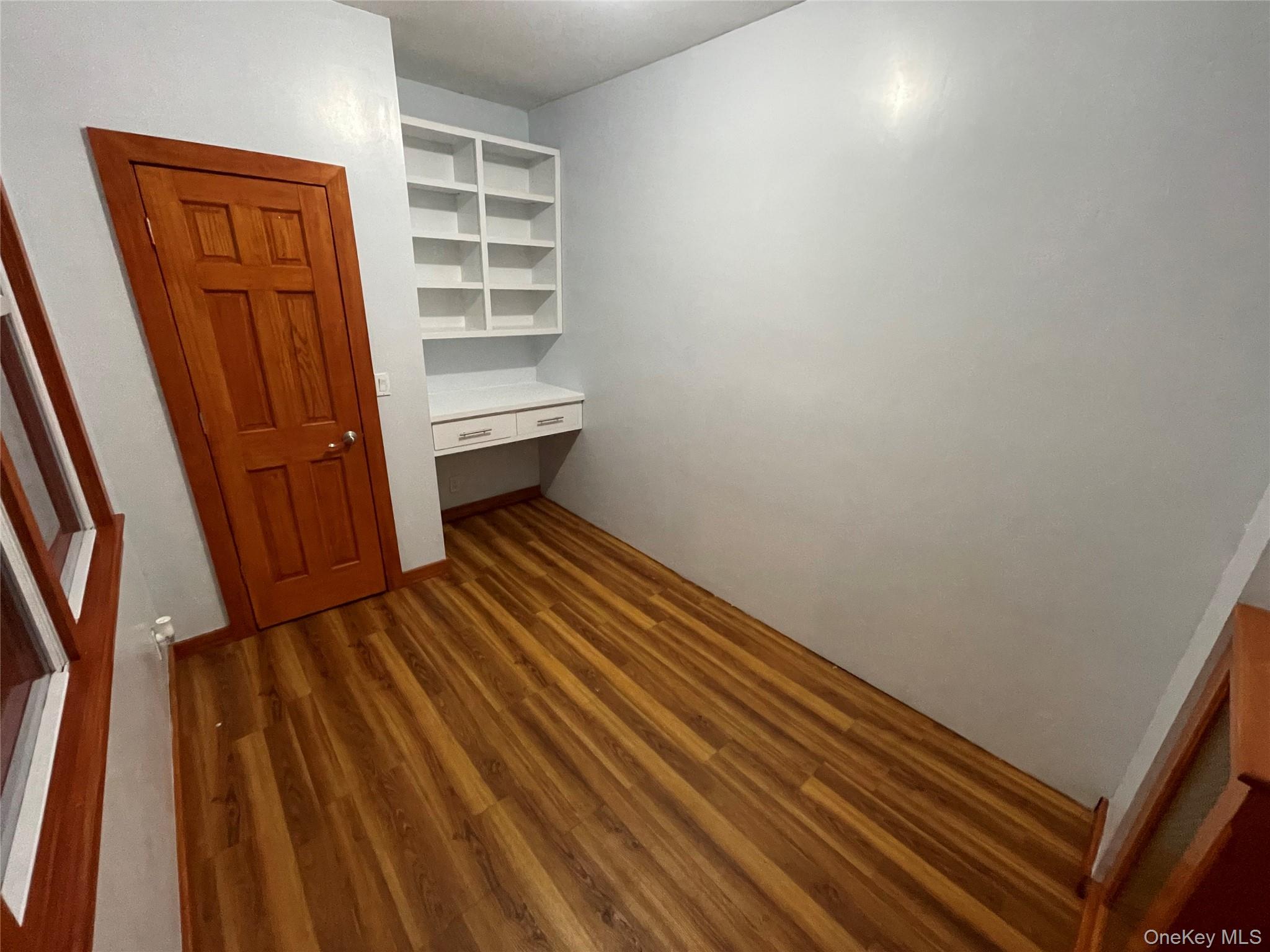 334 Locust Street Mount Vernon, NY 10550 - Photo 6 of 10 Unfurnished bedroom with built in desk and dark wood finished floors