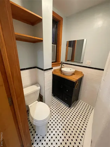 a bathroom with a toilet a sink and a mirror