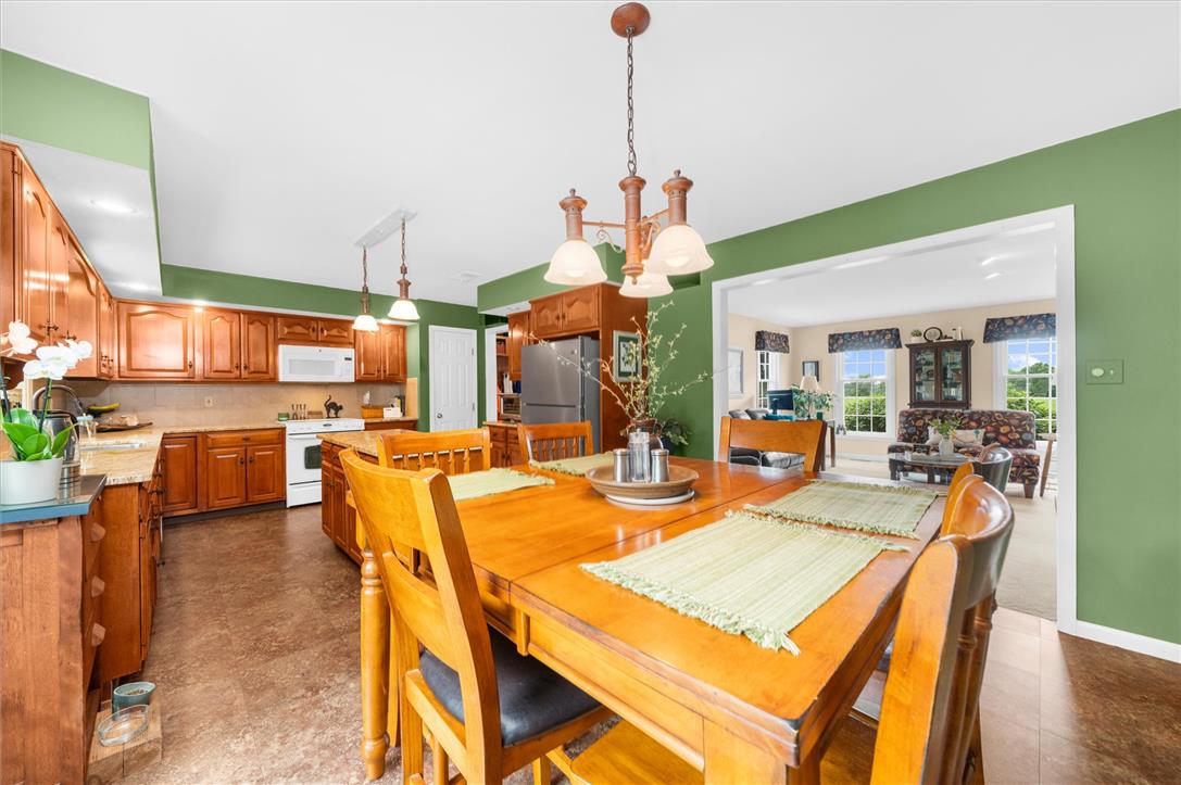 5616 Snowdrift Road Orefield, PA 18069 - Photo 7 of 36 A well-appointed kitchen flows seamlessly into a dining area, offering ample space for both cooking and gathering.