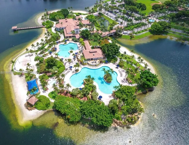 an aerial view of lake residential house with swimming pool and lawn chairs