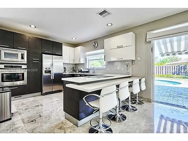 a kitchen with stainless steel appliances kitchen island granite countertop a sink and cabinets