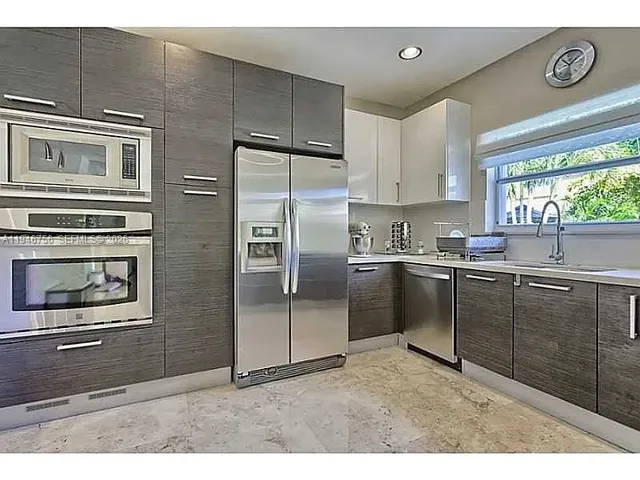 a kitchen with refrigerator cabinets and window