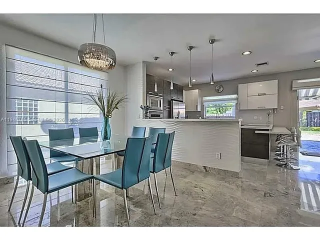 a kitchen with a dining table chairs and microwave