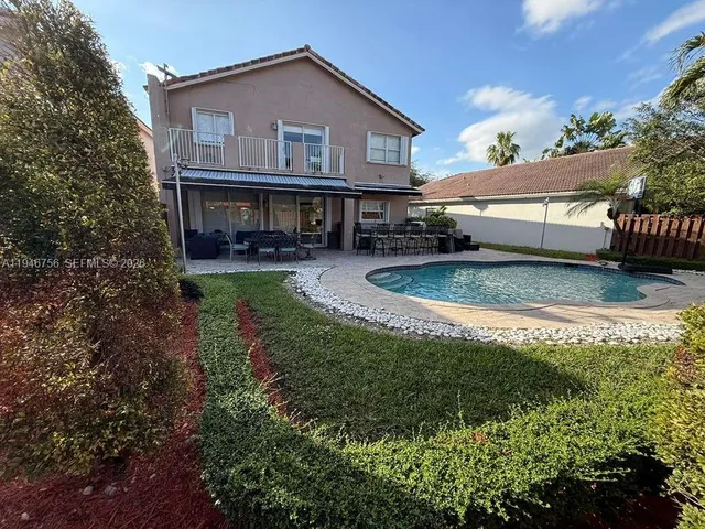 a view of a house with backyard and sitting area
