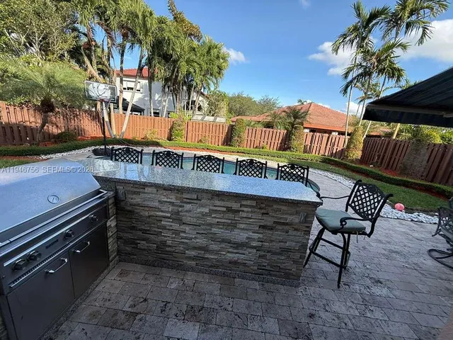 a view of a patio with table and chairs with wooden floor and plants