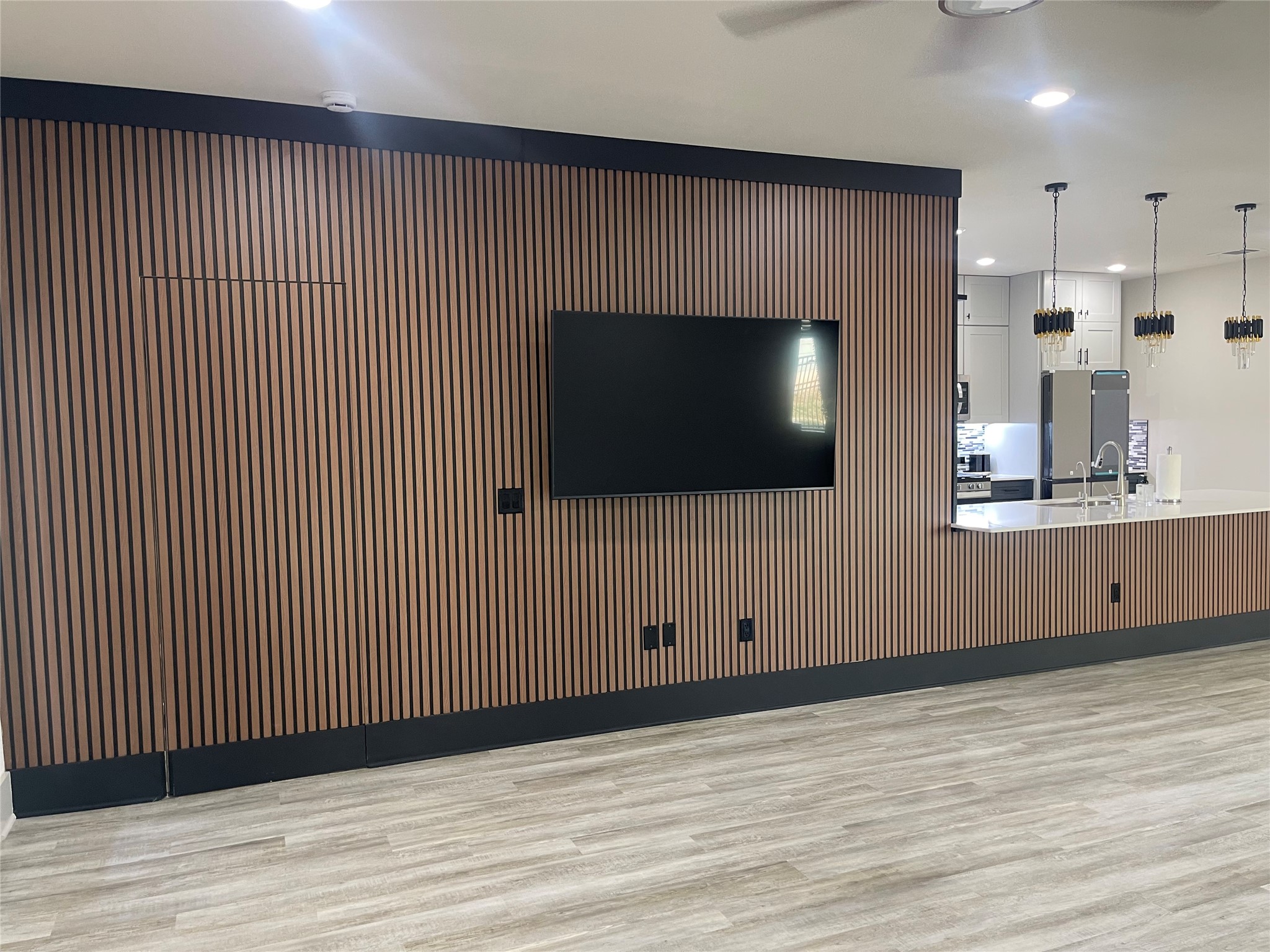 145 Merrick Road Georgetown, TX 78628 - Photo 31 of 32 Striking wood slat paneling defines the open concept living space and connects to the kitchen.
