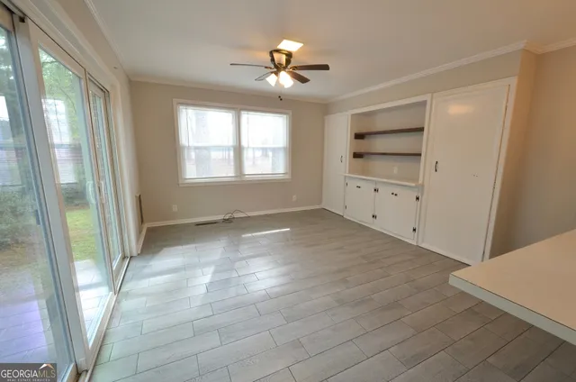 a view of empty room with a ceiling fan and window