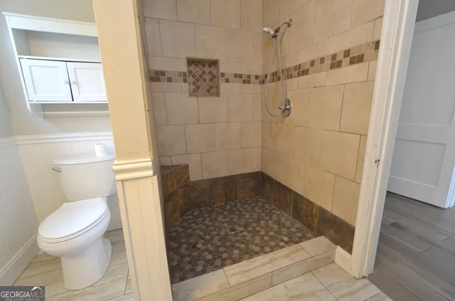 a bathroom with a toilet and a shower