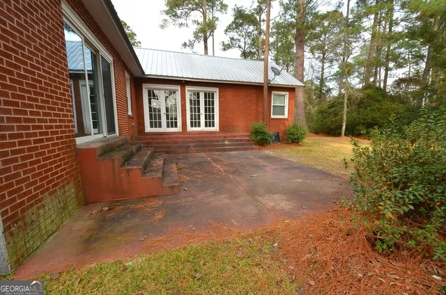 a view of a house with backyard and trees