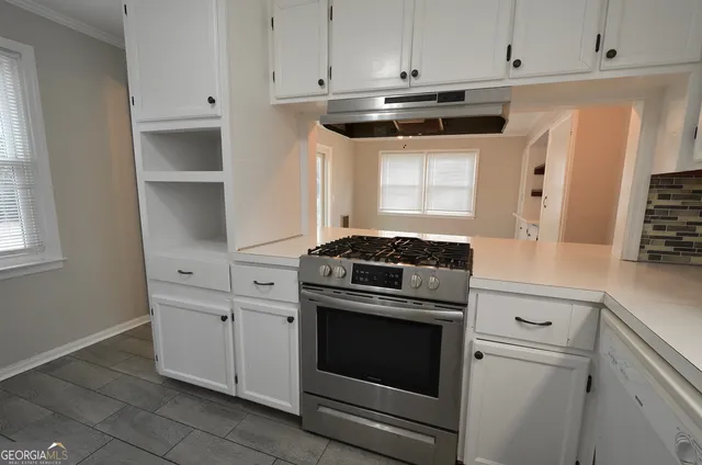 a kitchen with white cabinets and white appliances