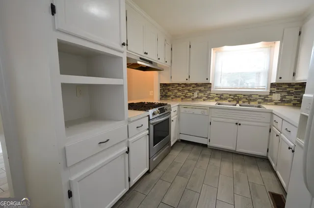 a kitchen with white cabinets and white appliances