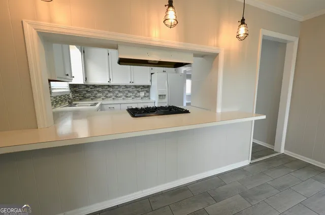a kitchen with kitchen island a stove and a refrigerator