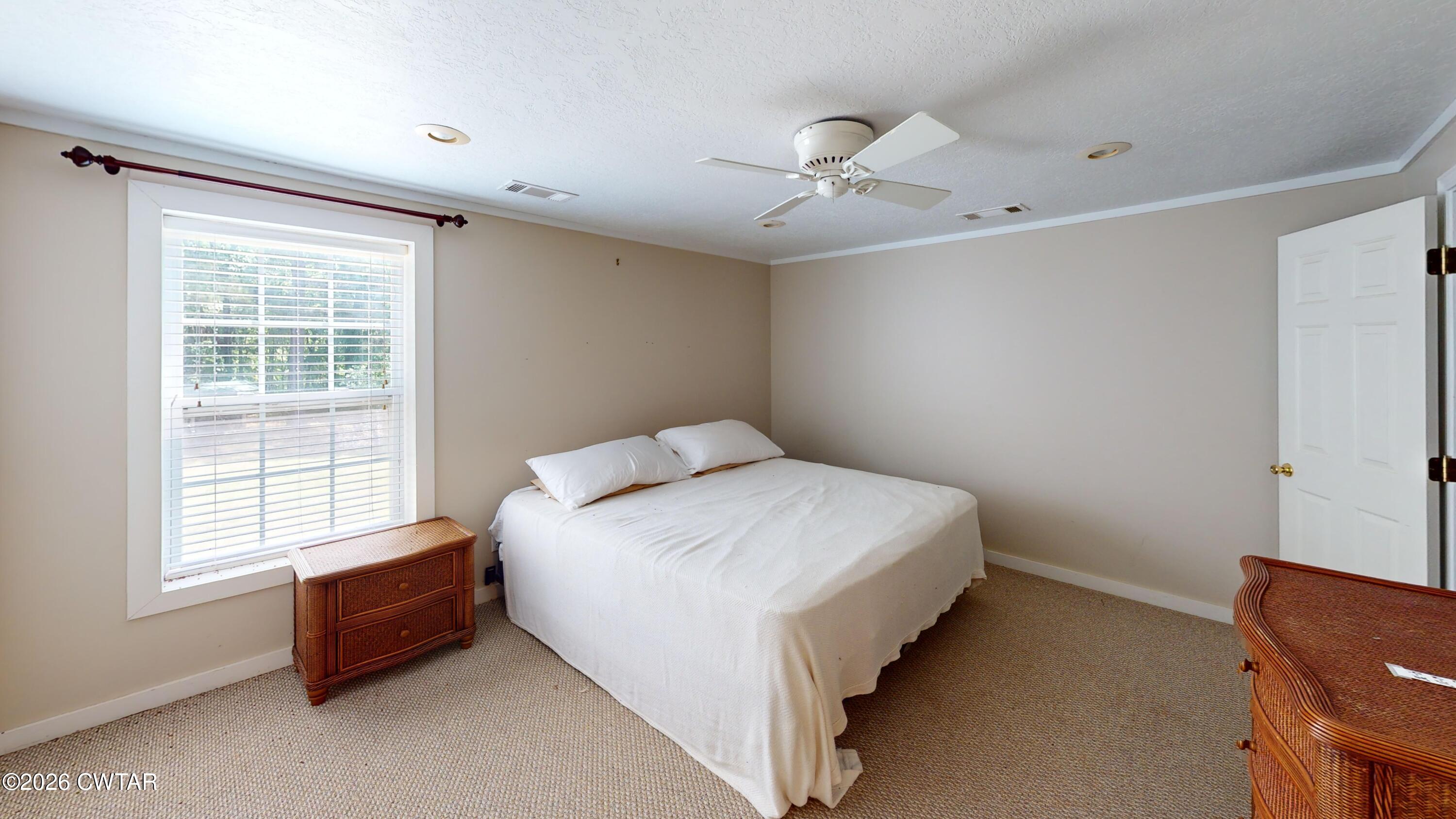 1532 Jackson Hill Road Hornbeak, TN 38232 - Photo 28 of 50 a spacious bedroom with a bed and a chair