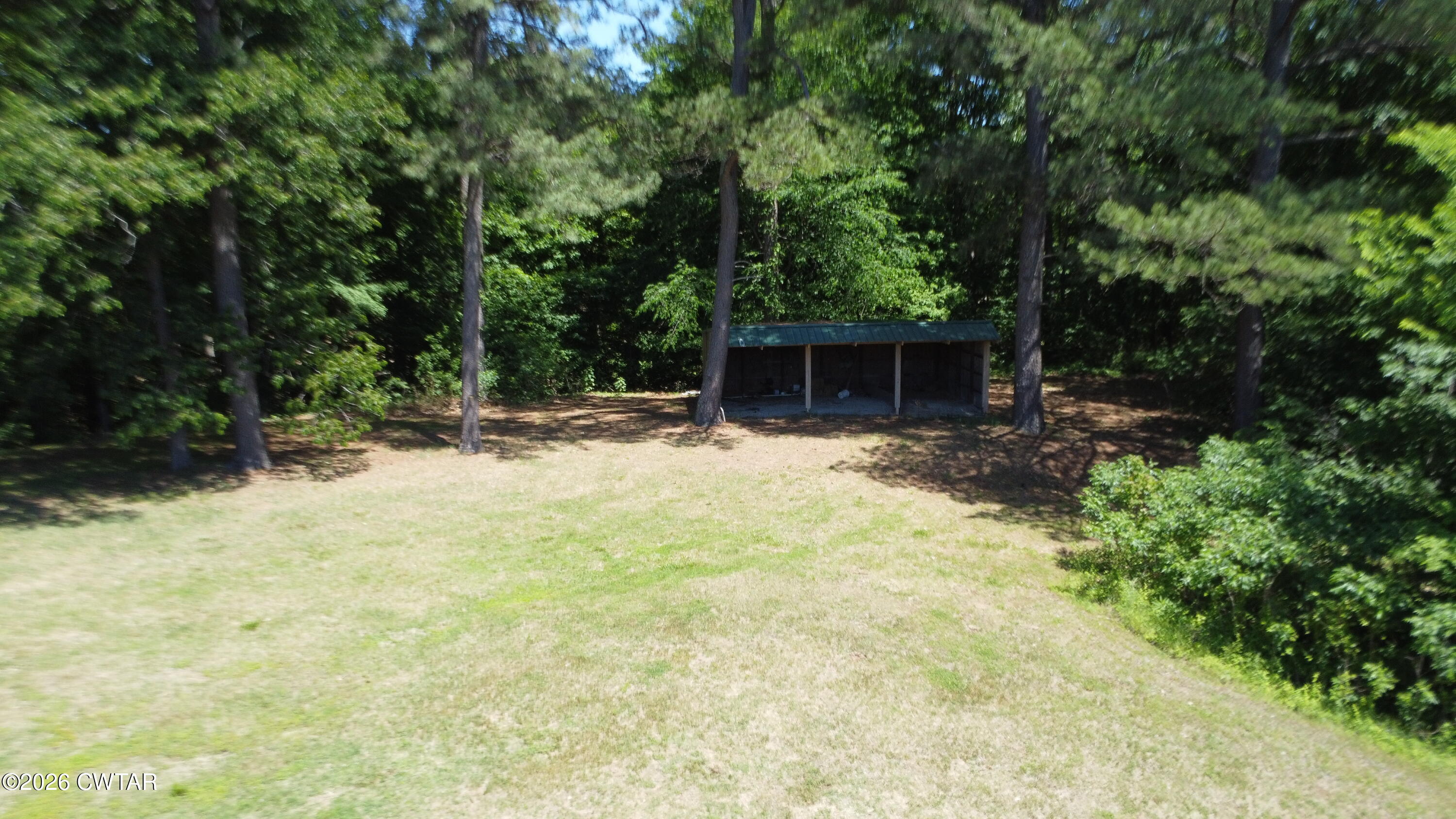 1532 Jackson Hill Road Hornbeak, TN 38232 - Photo 48 of 50 a backyard of a house with table and chairs under an umbrella