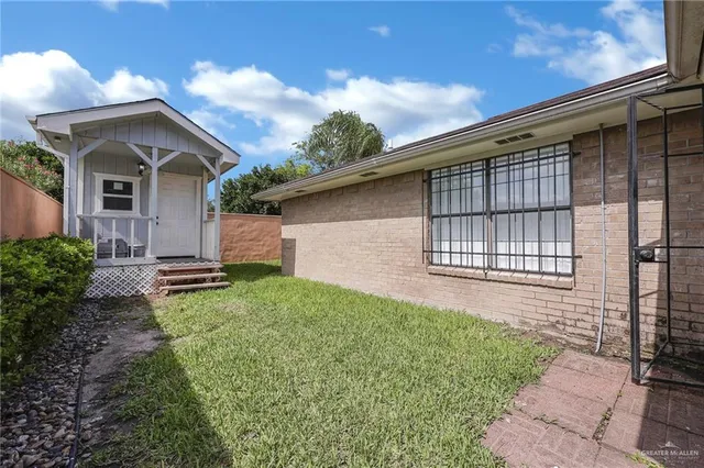 a backyard of a house with lots of green space and wooden fence