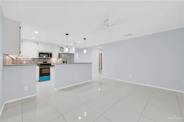 a kitchen with stainless steel appliances granite countertop a refrigerator a oven and a sink