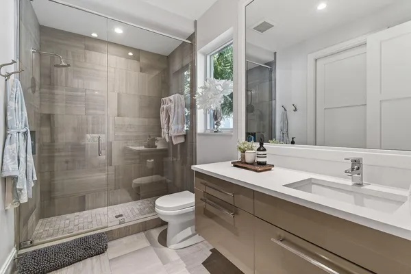 a bathroom with a double vanity sink mirror and shower