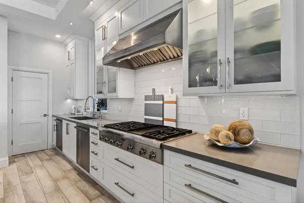 a kitchen with stainless steel appliances granite countertop a stove a sink and cabinets