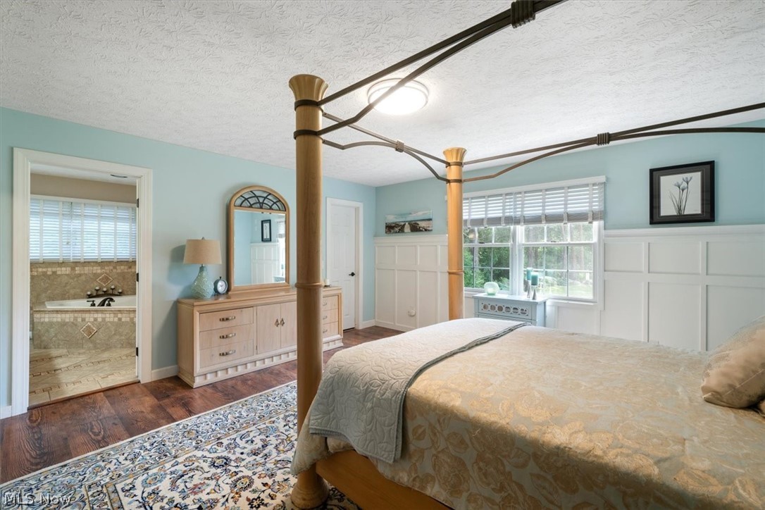 24876 Quarry Road Wellington, OH 44090 - Photo 22 of 50 Bedroom with dark hardwood / wood-style floors, a textured ceiling, and ensuite bath