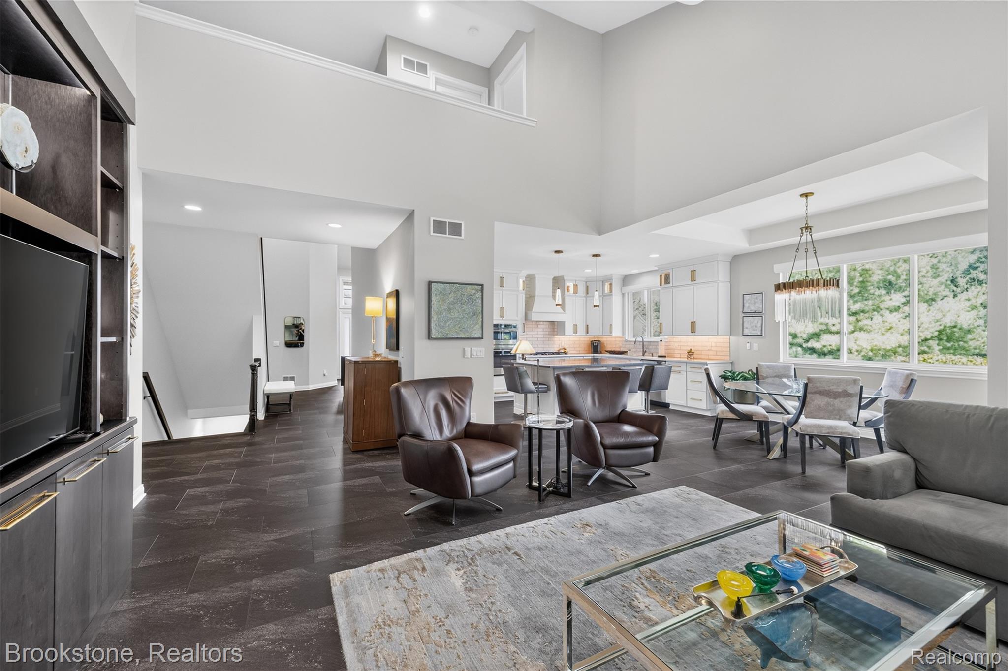 2167 Sanctuary Court Rochester, MI 48309 - Photo 10 of 68 Expansive open-concept living area featuring high ceilings, dark tile flooring, a built-in entertainment center, and abundant natural light from large windows