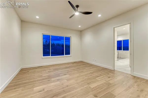 a view of empty room with wooden floor and window
