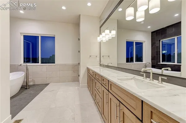 a spacious bathroom with a sink double vanity granite and a large mirror
