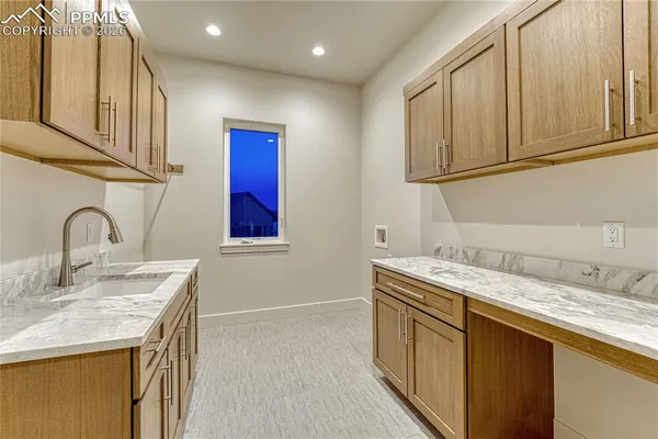 a kitchen with stainless steel appliances granite countertop a sink and cabinets with wooden floor