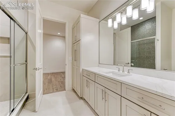 a spacious bathroom with a mirror sink and shower