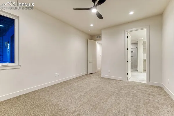 an empty room with fan and entrance