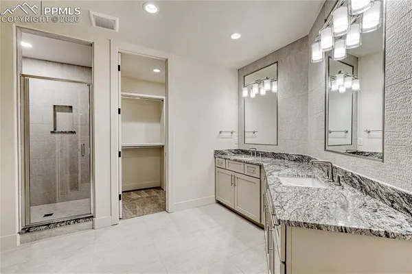a bathroom with a granite countertop sink mirror and shower