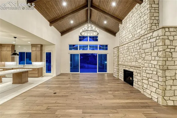a view of an empty room with a fireplace and a chandelier