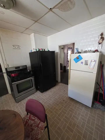 a kitchen with a table chairs and white cabinets