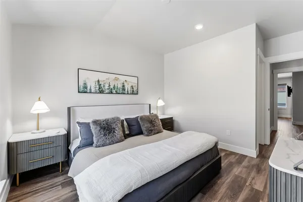 a bedroom with bed and wooden floor