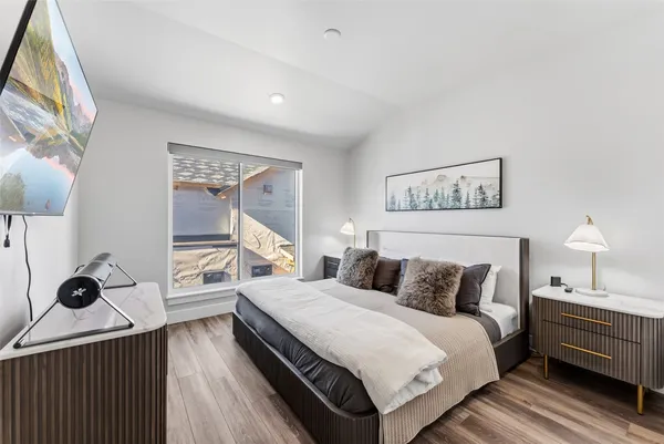 a bedroom with bed and a painting on the wall