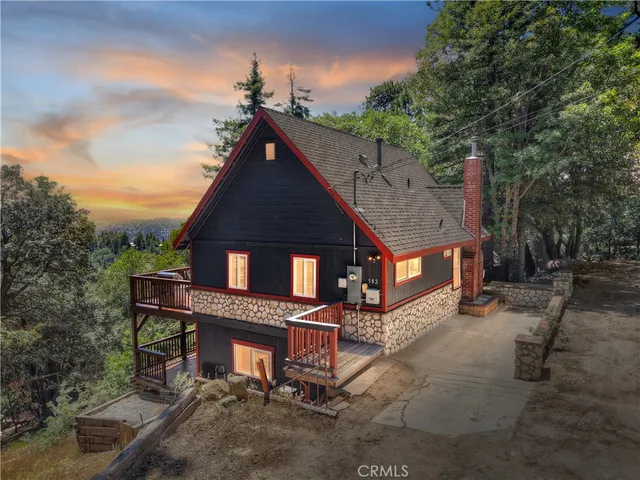 a view of a house with wooden deck and furniture