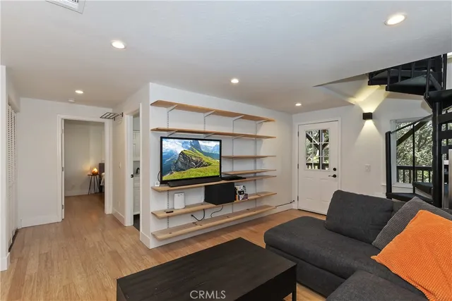 a view of a patio with couches table and chairs under an umbrella with a barbeque