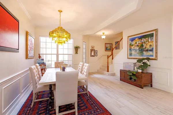 a view of a dining room with furniture a chandelier and wooden floor