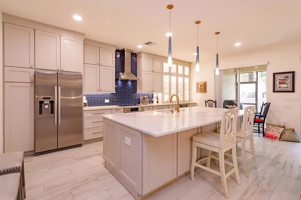 a kitchen with stainless steel appliances kitchen island granite countertop a sink a counter and chairs