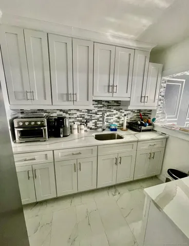 a kitchen with stainless steel appliances granite countertop a sink a stove a microwave and cabinets