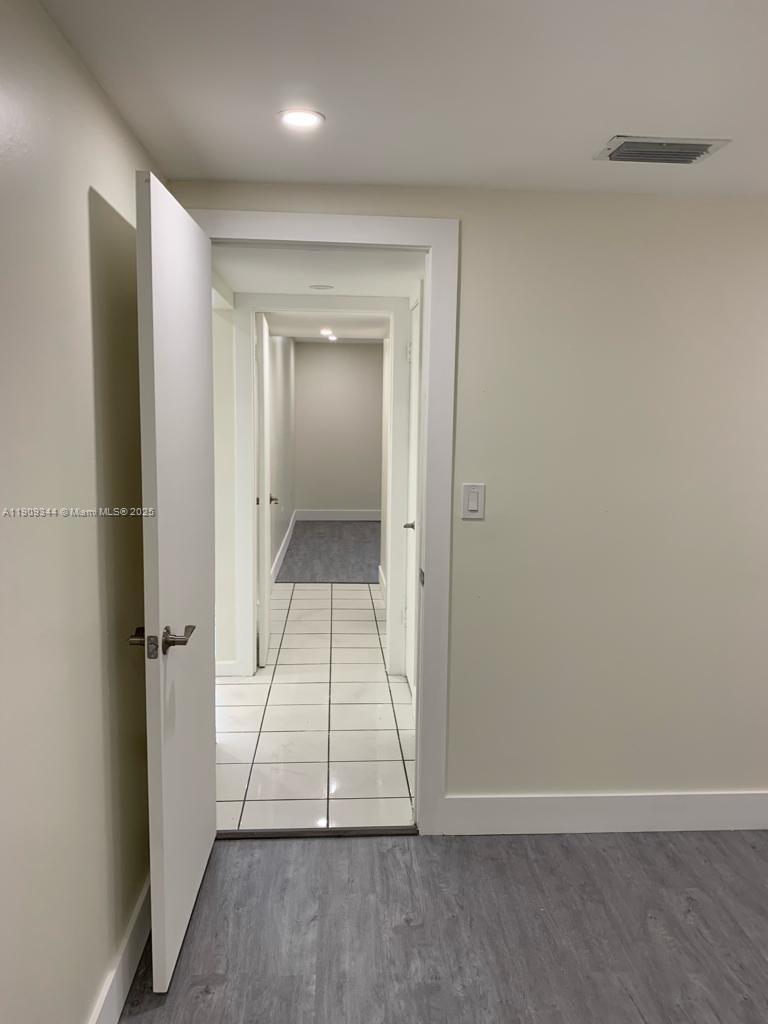 1555 West 44th Place, Unit 234 Hialeah, FL 33012 - Photo 16 of 38 an empty room with wooden floor and a bathroom