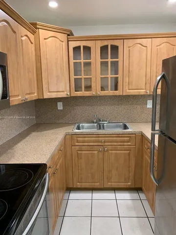 a kitchen with a refrigerator a sink and cabinets