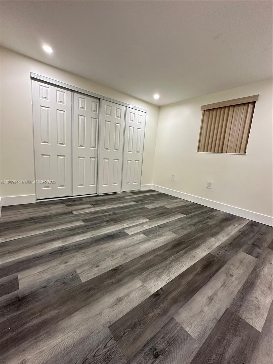 1555 West 44th Place, Unit 234 Hialeah, FL 33012 - Photo 27 of 38 a view of an empty room with wooden floor and a window